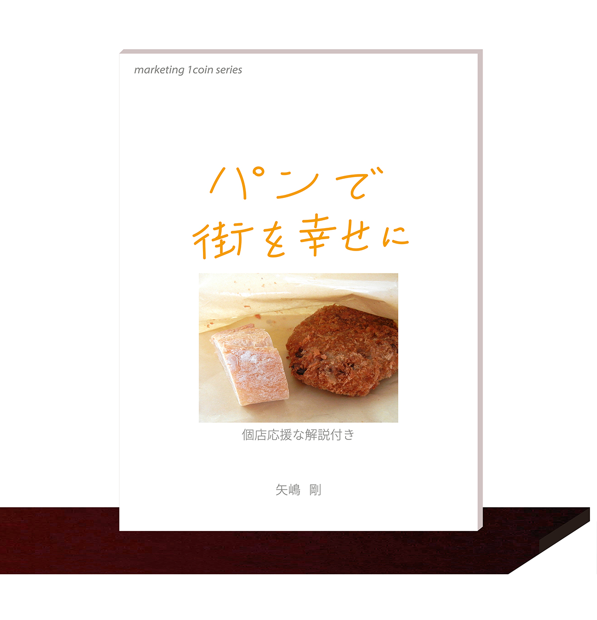矢嶋剛・著。マーケティング・１コイン・シリーズ(3)『パンで街を幸せに』（矢嶋ストーリー刊）が本棚の棚板の上に並んでいます。矢嶋ストーリー公式サイトのコツ本ページに掲載されている画像です。